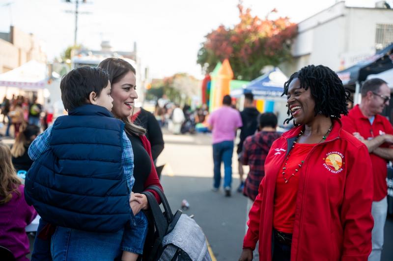 Senator Smallwood-Cuevas is pictured greeting family members at a community healthcare event.
