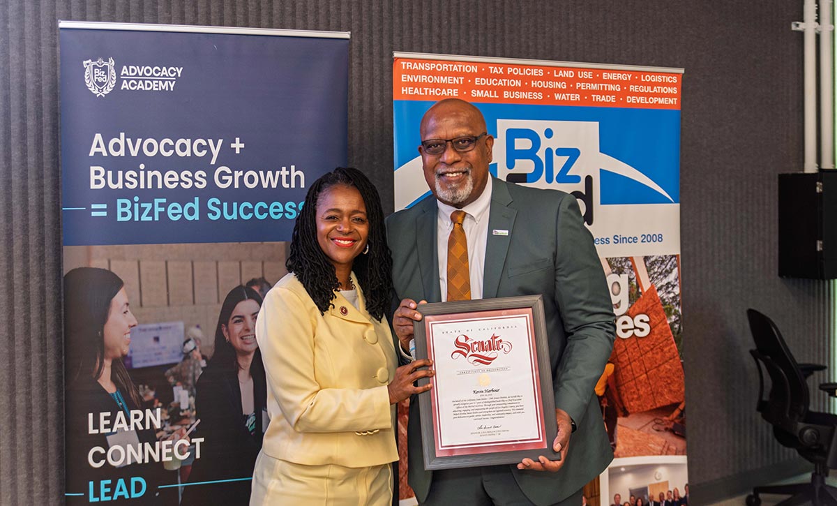 Senator Lola Smallwood-Cuevas presents an award to Kevin Harbour.