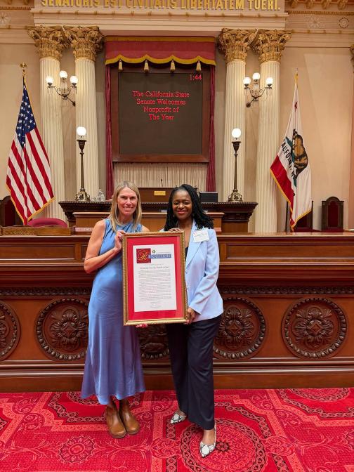Julie Kirk of Westside Family Health Center receiving the Nonprofit of the Year resolution from Senator Lola Smallwood-Cuevas. es the Nonprofit of the Year resolution from Senator Lola Smallwood-Cuevas.