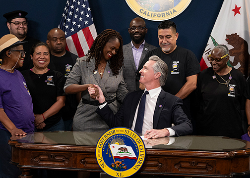 Senator Lola Smallwood-Cuevas shakes Governor Newsom’s hand after his signing of one of her bills.
